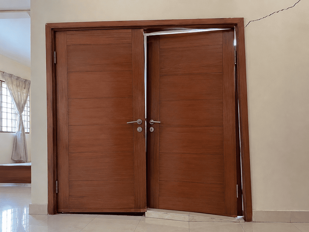 Distorted door frame caused by differential settlement with visible gap and wall cracks